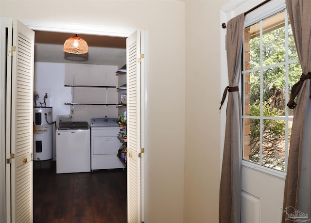 laundry room featuring dark wood-type flooring, washing machine and dryer, laundry area, and water heater