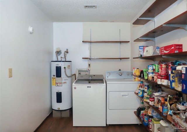 washroom featuring a textured ceiling, electric water heater, laundry area, visible vents, and washer and dryer