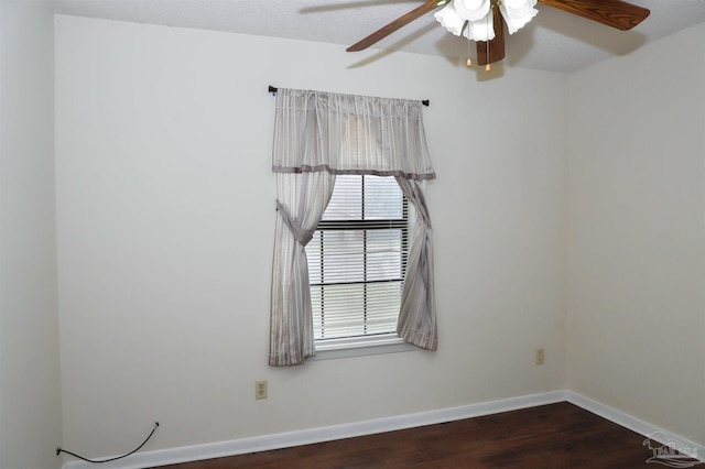 spare room featuring a ceiling fan, baseboards, and wood finished floors