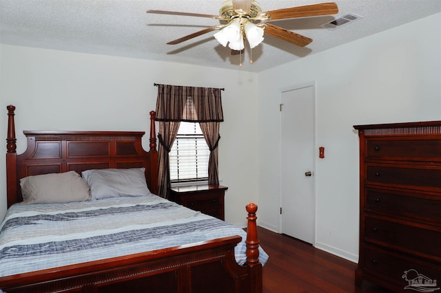 bedroom featuring visible vents, a ceiling fan, a textured ceiling, wood finished floors, and baseboards