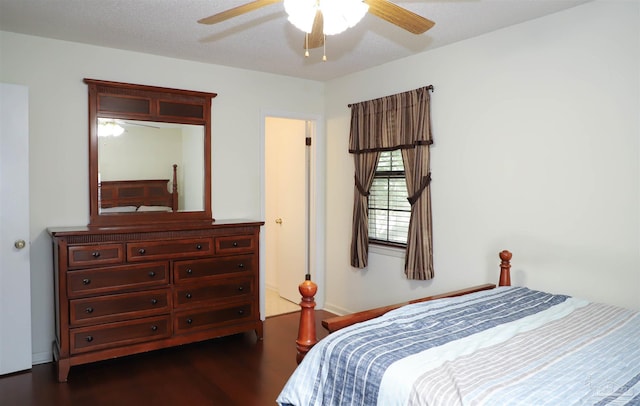 bedroom with a textured ceiling, dark wood finished floors, a ceiling fan, and baseboards