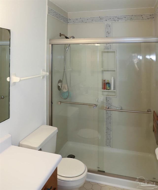 bathroom with a stall shower, vanity, and toilet