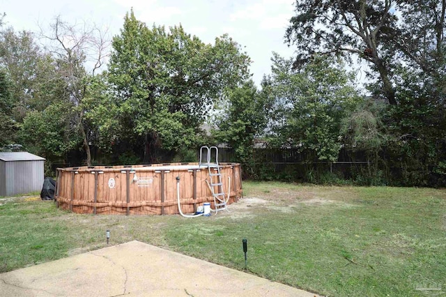 view of yard featuring an outbuilding, a patio area, fence, and a storage unit