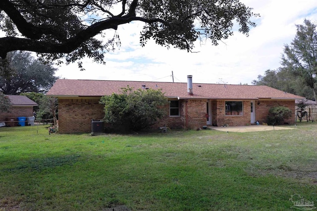 back of house featuring central AC, brick siding, fence, a yard, and a patio area