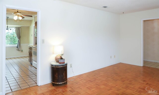 spare room featuring a ceiling fan, visible vents, a textured ceiling, and baseboards