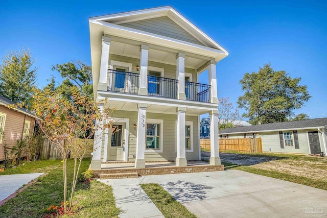 greek revival house with a front lawn, a balcony, and a porch