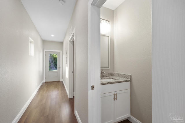 corridor with dark hardwood / wood-style floors and sink