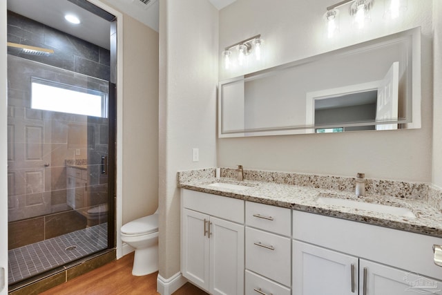 bathroom featuring walk in shower, vanity, toilet, and hardwood / wood-style floors