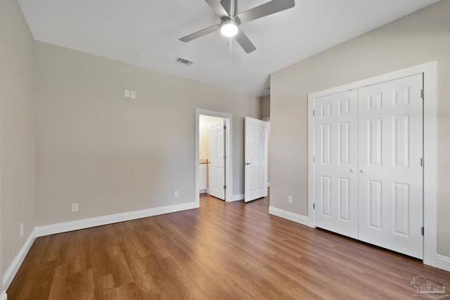 unfurnished bedroom featuring ceiling fan, hardwood / wood-style floors, and a closet