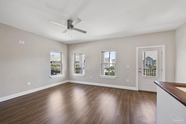 interior space featuring ceiling fan, a wealth of natural light, and dark hardwood / wood-style flooring