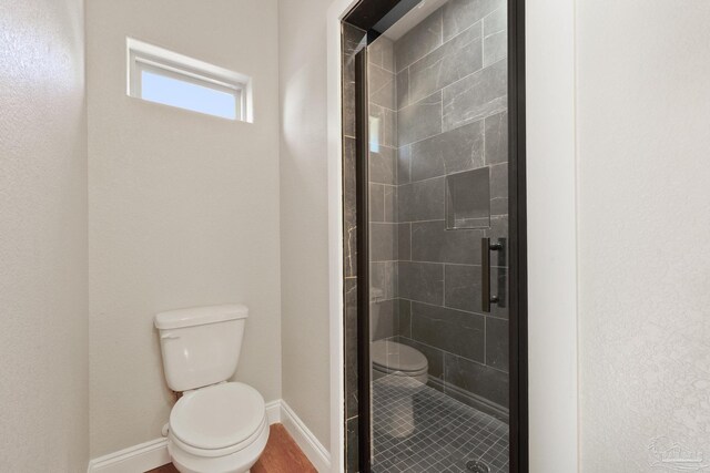 bathroom with an enclosed shower and toilet