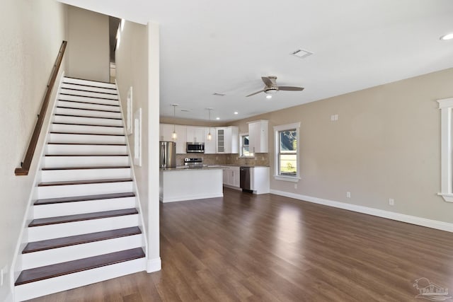 unfurnished living room featuring ceiling fan and dark hardwood / wood-style floors