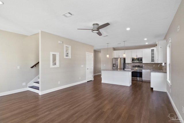 unfurnished living room with dark hardwood / wood-style flooring, sink, and ceiling fan