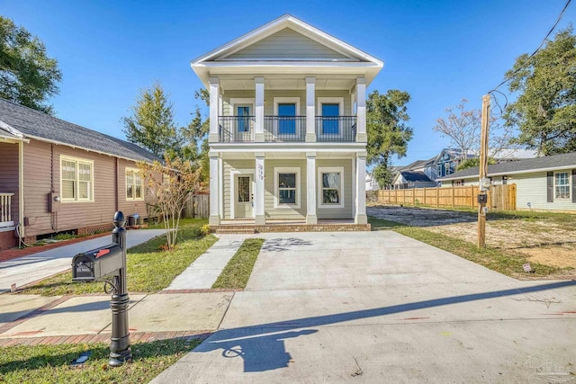 greek revival house featuring a balcony and covered porch