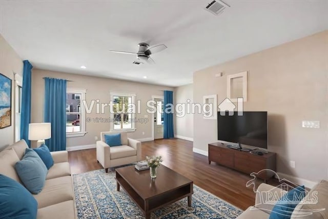 living room featuring dark wood-type flooring and ceiling fan