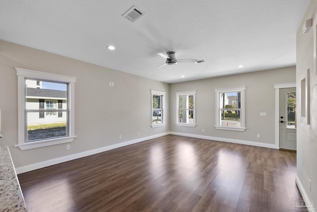 unfurnished room with ceiling fan, plenty of natural light, and dark hardwood / wood-style floors