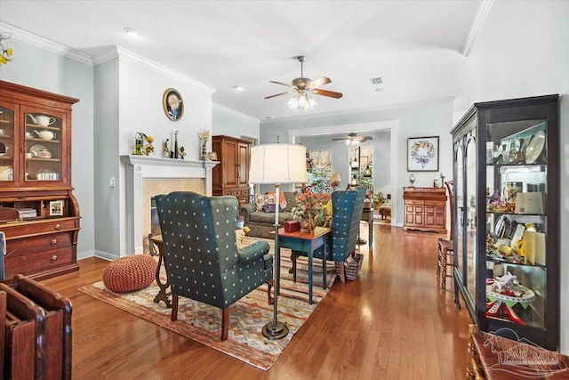 living room featuring crown molding, light hardwood / wood-style flooring, and ceiling fan