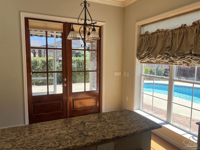 doorway featuring crown molding, french doors, and a chandelier