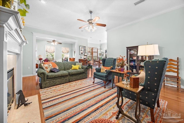 living room featuring ceiling fan, crown molding, a textured ceiling, and hardwood / wood-style floors