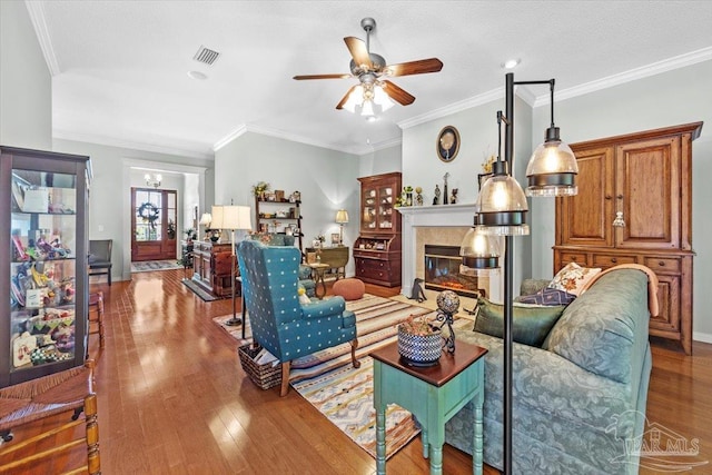 living room featuring hardwood / wood-style floors, crown molding, and ceiling fan