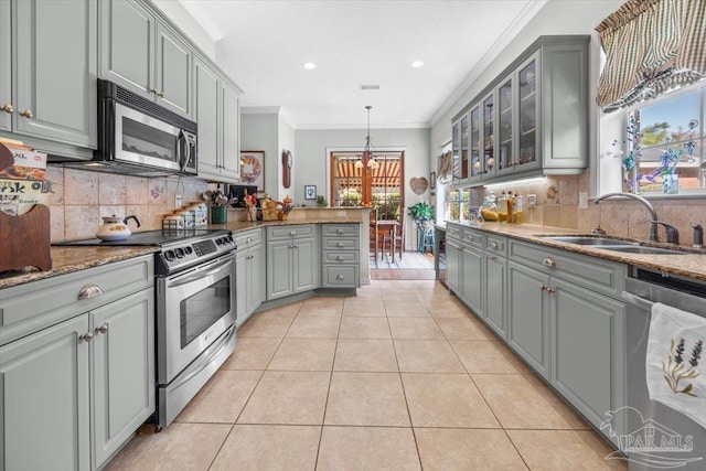kitchen featuring a sink, gray cabinets, stainless steel appliances, and crown molding