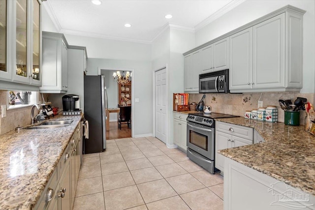 kitchen featuring sink, stainless steel appliances, light stone counters, ornamental molding, and light tile patterned floors