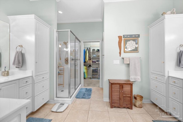 bathroom with vanity, crown molding, tile patterned flooring, and a shower with door