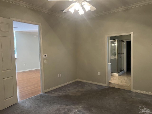 carpeted spare room featuring baseboards, a ceiling fan, and ornamental molding