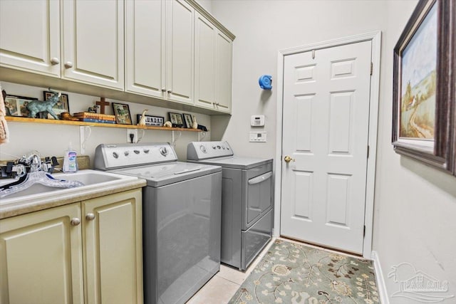 washroom featuring sink, light tile patterned floors, cabinets, and separate washer and dryer