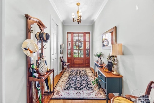 entrance foyer with light hardwood / wood-style floors, crown molding, and a chandelier