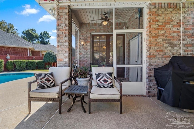 view of patio featuring grilling area, a fenced in pool, and ceiling fan