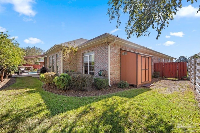 view of side of home with a patio, a storage shed, and a lawn