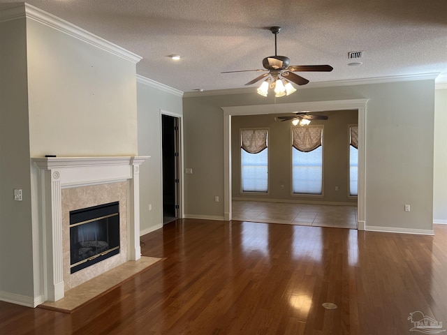unfurnished living room with ceiling fan, visible vents, wood finished floors, and a fireplace
