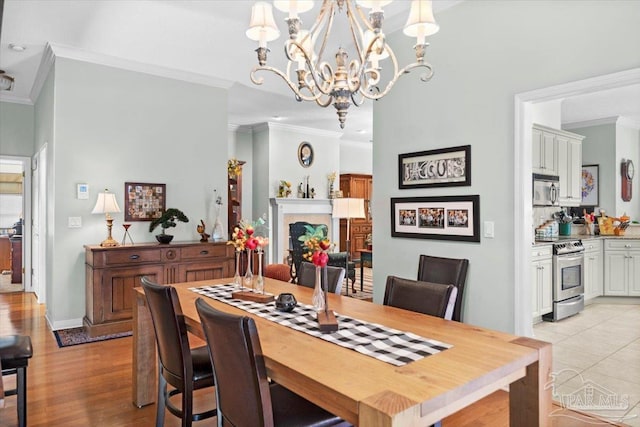 dining room featuring ornamental molding, light hardwood / wood-style flooring, and a chandelier