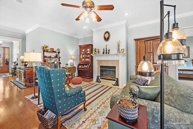 living room featuring ornamental molding, light hardwood / wood-style floors, and ceiling fan