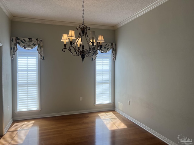 unfurnished dining area with an inviting chandelier, a textured ceiling, plenty of natural light, and wood finished floors