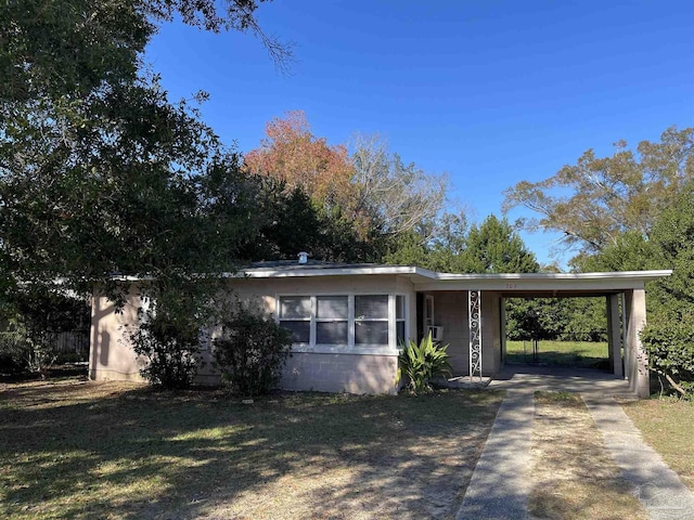 view of front of home with a front lawn and a carport