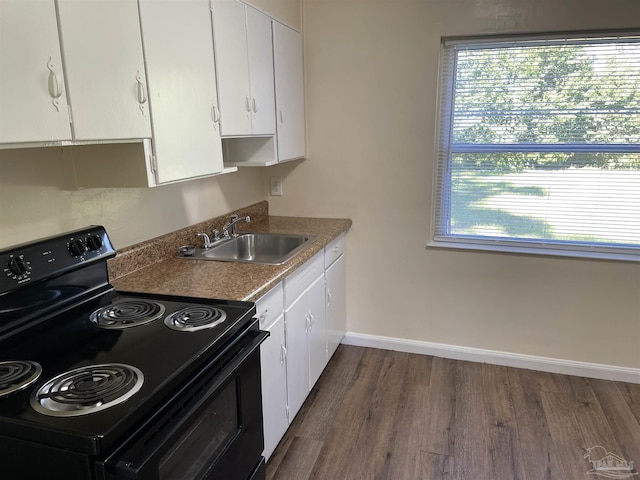 kitchen featuring dark hardwood / wood-style floors, black electric range, white cabinets, and sink