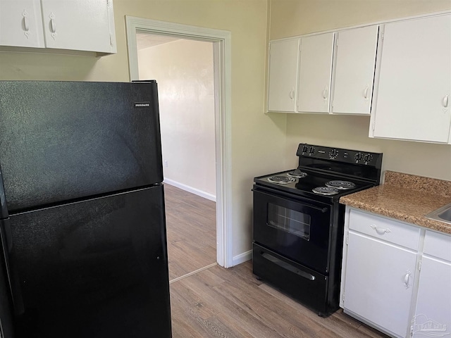 kitchen featuring black appliances, white cabinetry, and light hardwood / wood-style floors