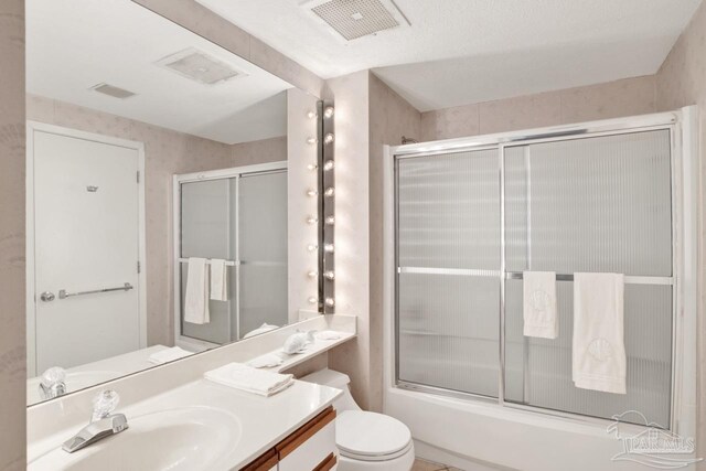 full bathroom with vanity, toilet, and enclosed tub / shower combo