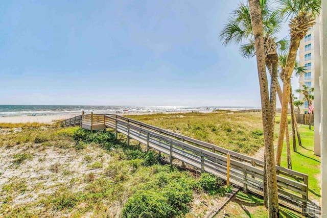 view of yard featuring a water view and a beach view