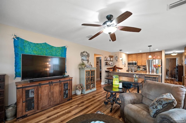 living room with ceiling fan and light hardwood / wood-style flooring