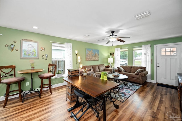 living room with wood-type flooring, ceiling fan, and a healthy amount of sunlight