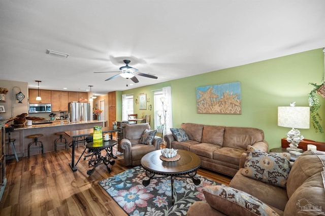 living room featuring ceiling fan and dark hardwood / wood-style flooring