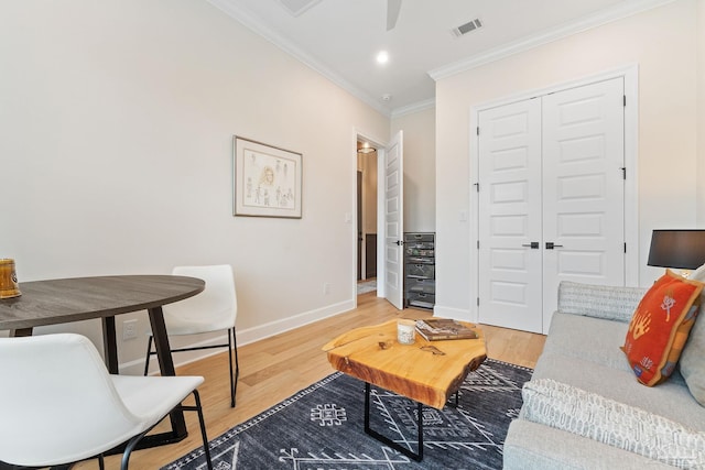 living room featuring hardwood / wood-style floors, ceiling fan, and ornamental molding