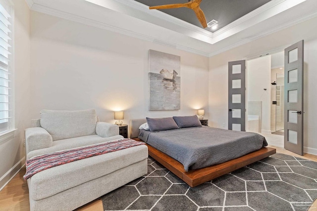 bedroom with dark wood-type flooring, ceiling fan, ensuite bath, and crown molding