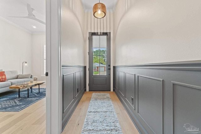 doorway to outside featuring ornamental molding, light hardwood / wood-style flooring, and ceiling fan