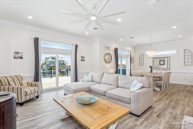 living room featuring ornamental molding, light wood finished floors, plenty of natural light, and recessed lighting