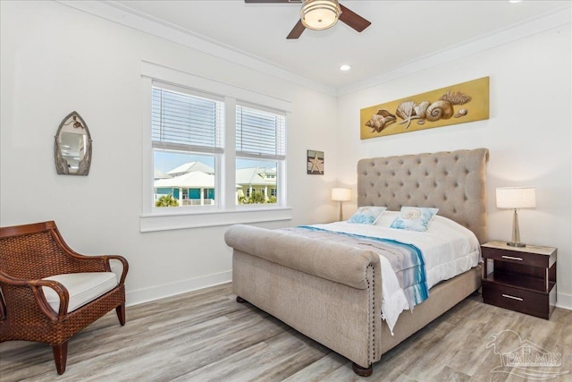 bedroom with baseboards, ceiling fan, light wood finished floors, and crown molding