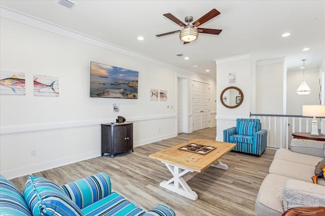 living room with crown molding, recessed lighting, visible vents, wood finished floors, and baseboards